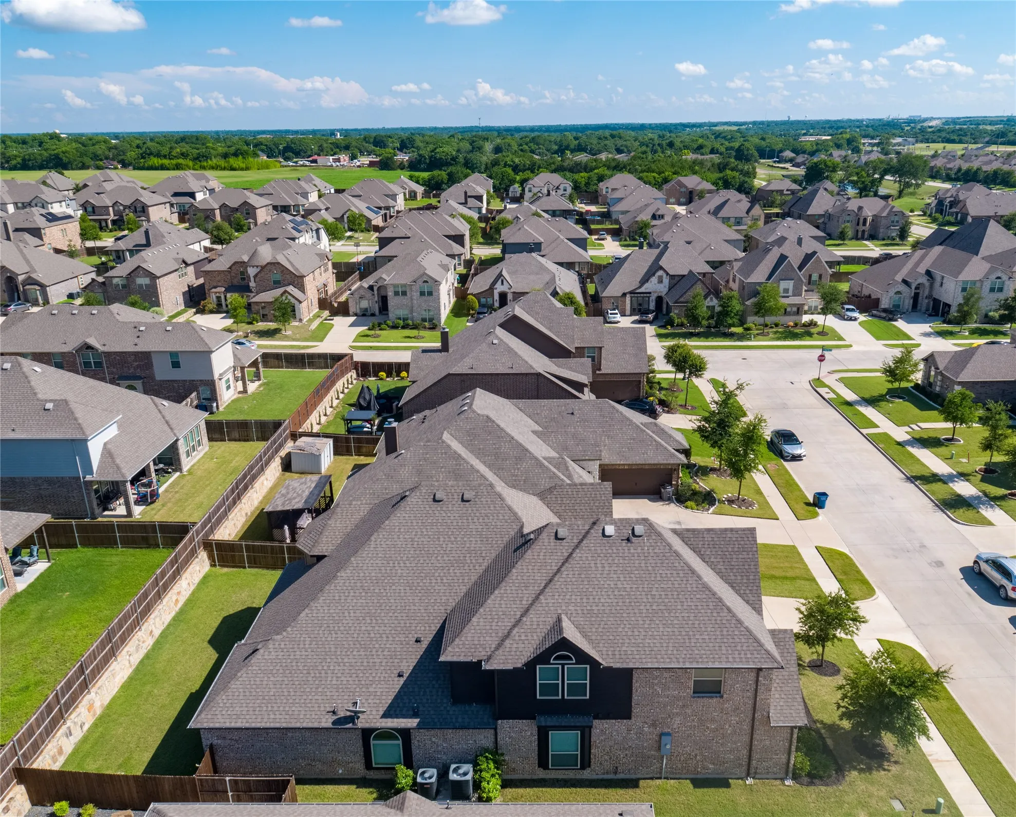 Aerial view of a residential neighborhood featuring multiple single-family homes with pitched roofs and brick or siding exteriors