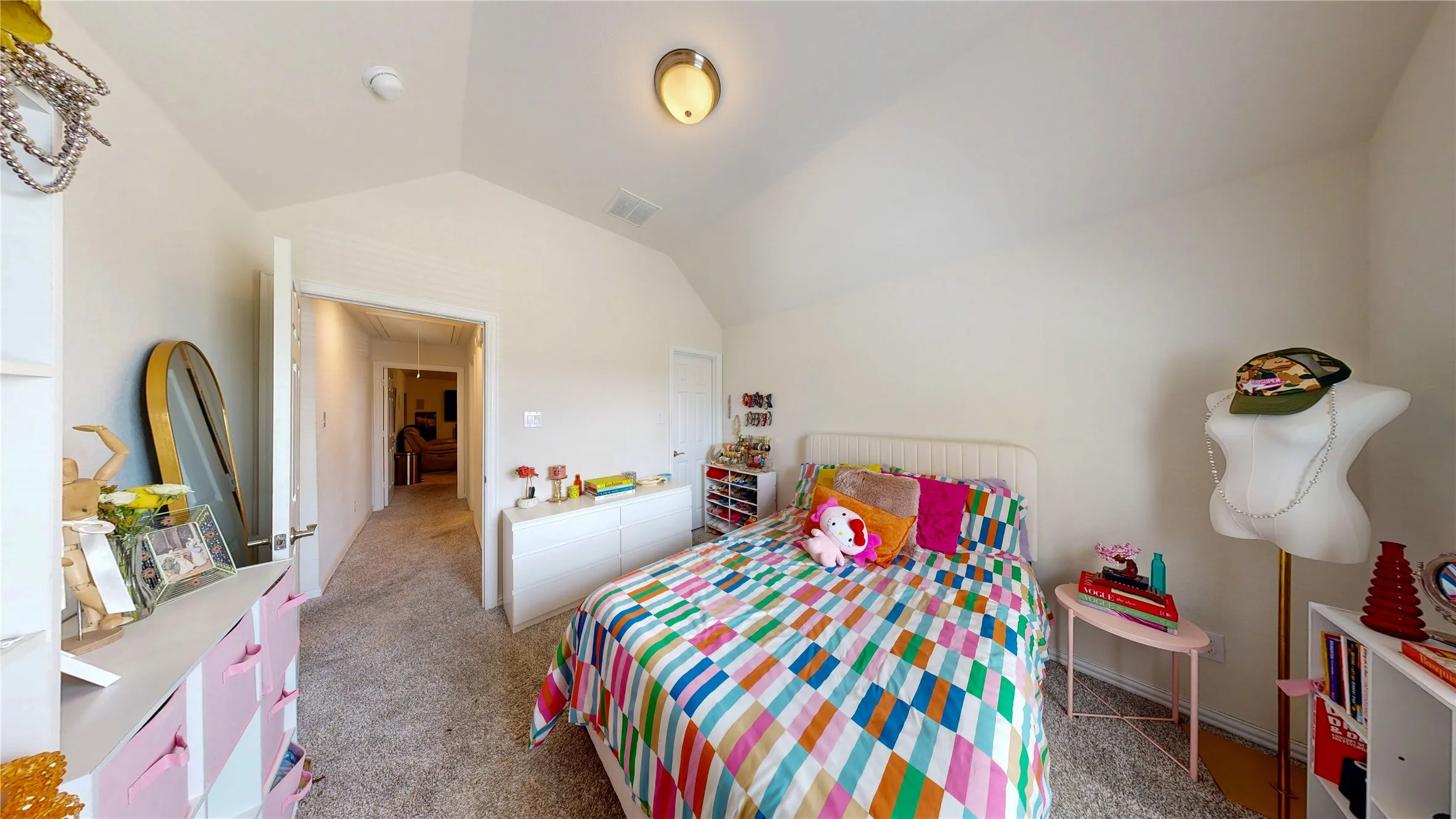 Carpeted room featuring a vaulted ceiling with a flush-mount light fixture