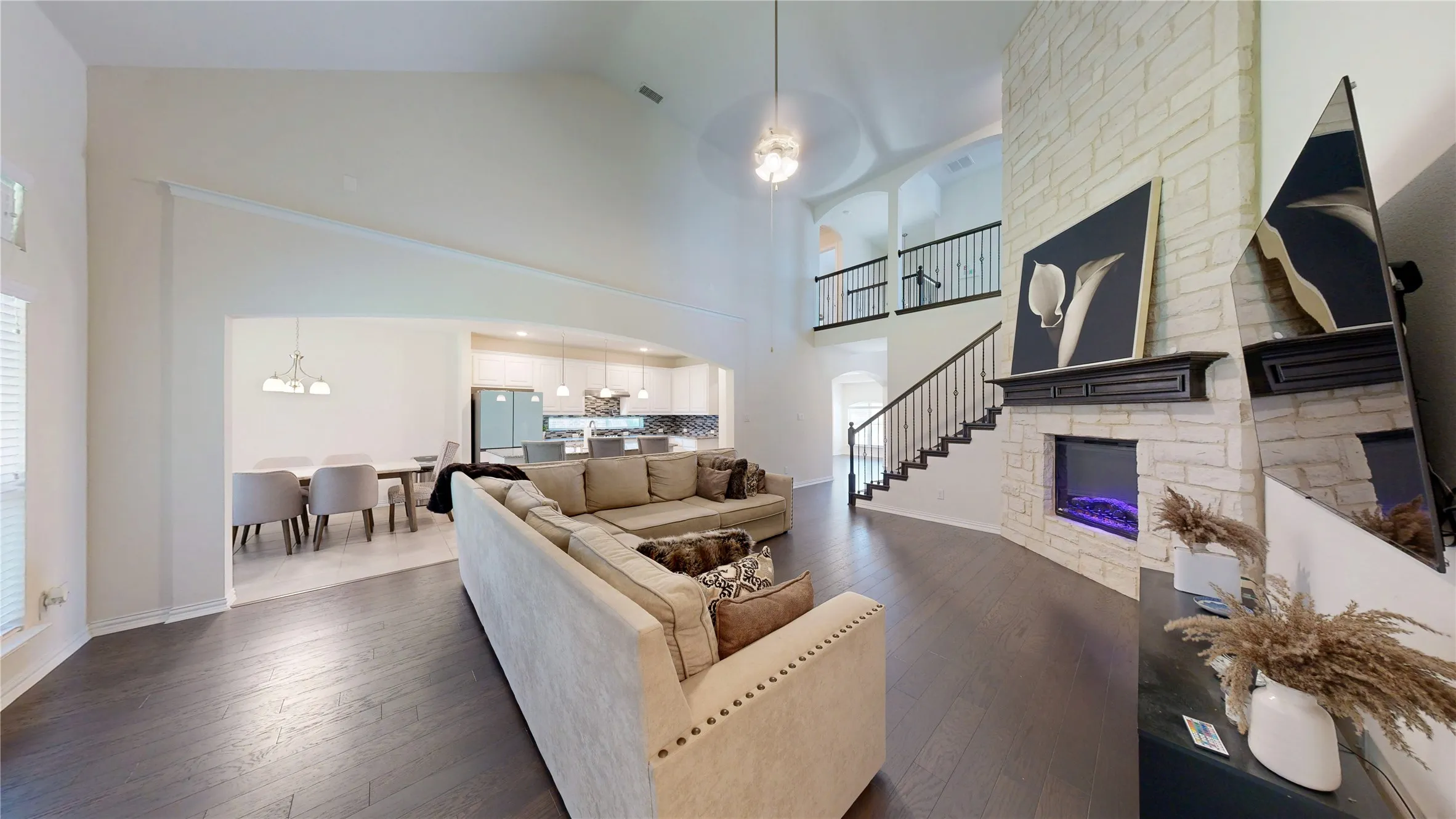 Spacious living area featuring high vaulted ceilings, wood-finish flooring, and an open concept layout