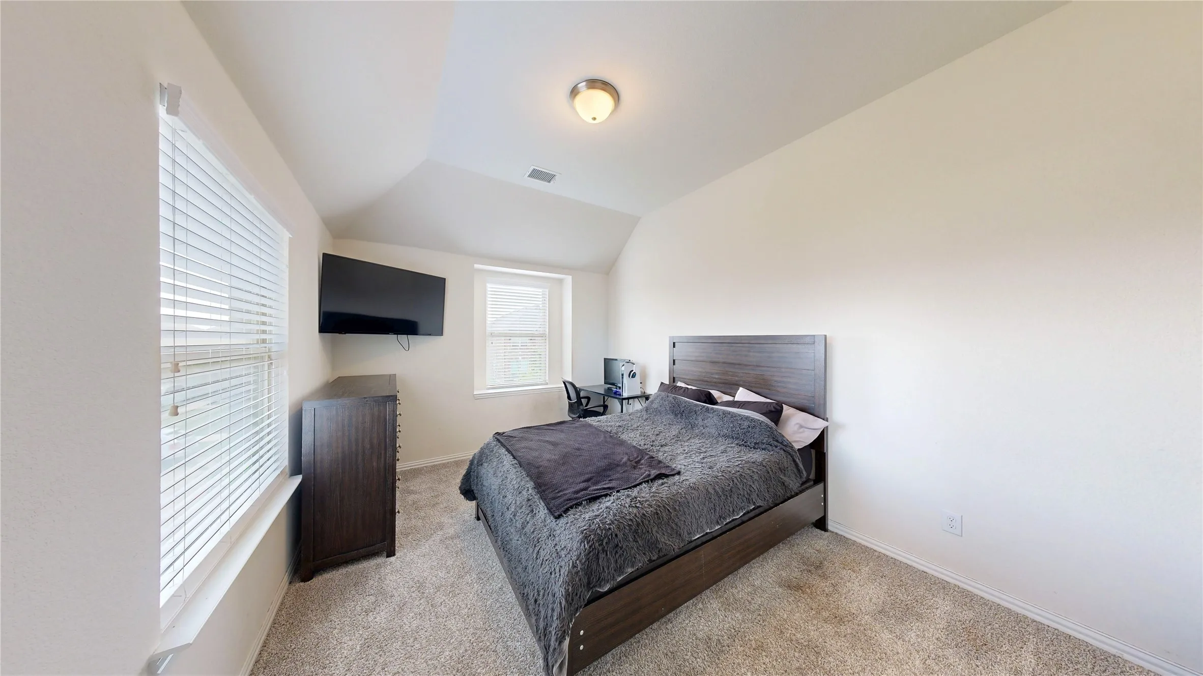Carpeted room with vaulted ceilings and recessed lighting