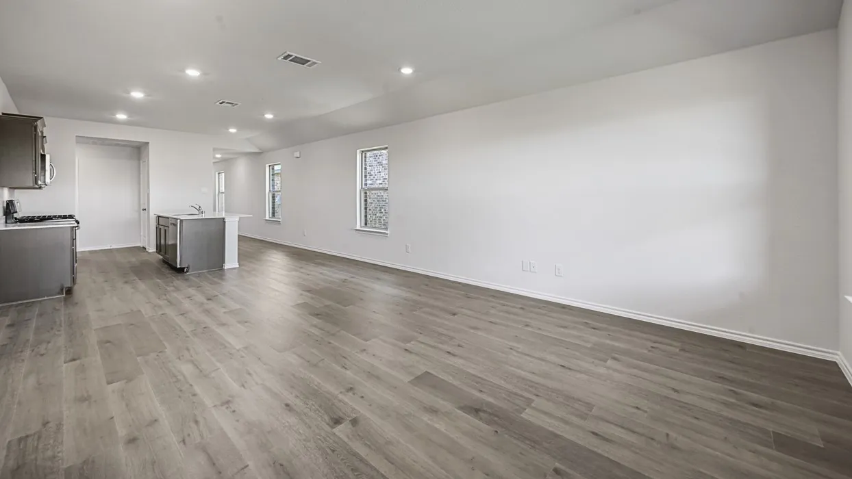Open-concept living area featuring wood-finish flooring, recessed lighting, and ample natural light from multiple windows