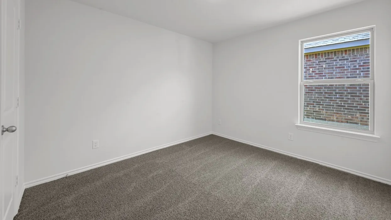 Carpeted room with white walls, a single window, and a white paneled door