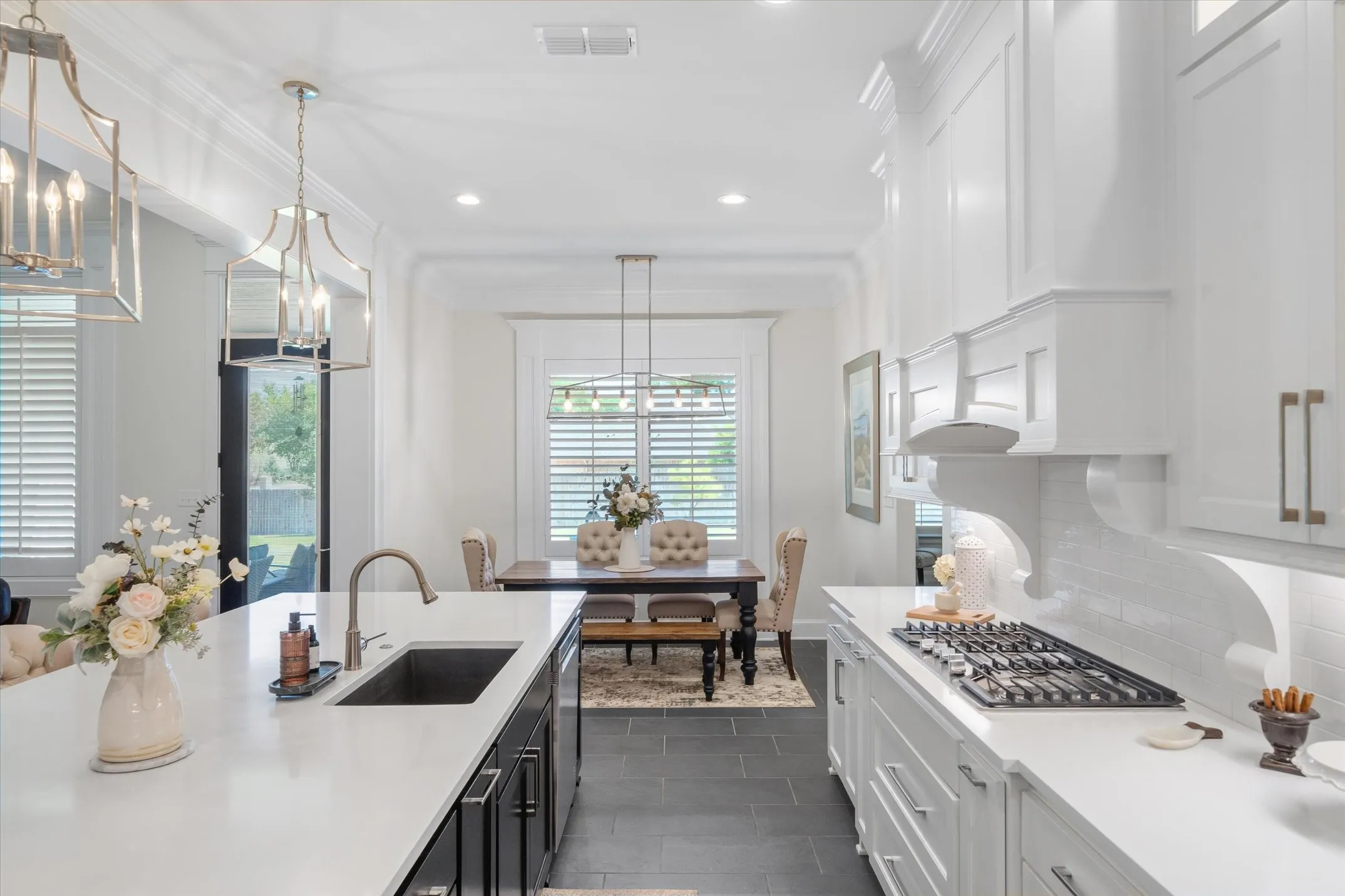 Quartz countertops, under cabinet lighting and upper ceiling cabinets with glass doors and lights
