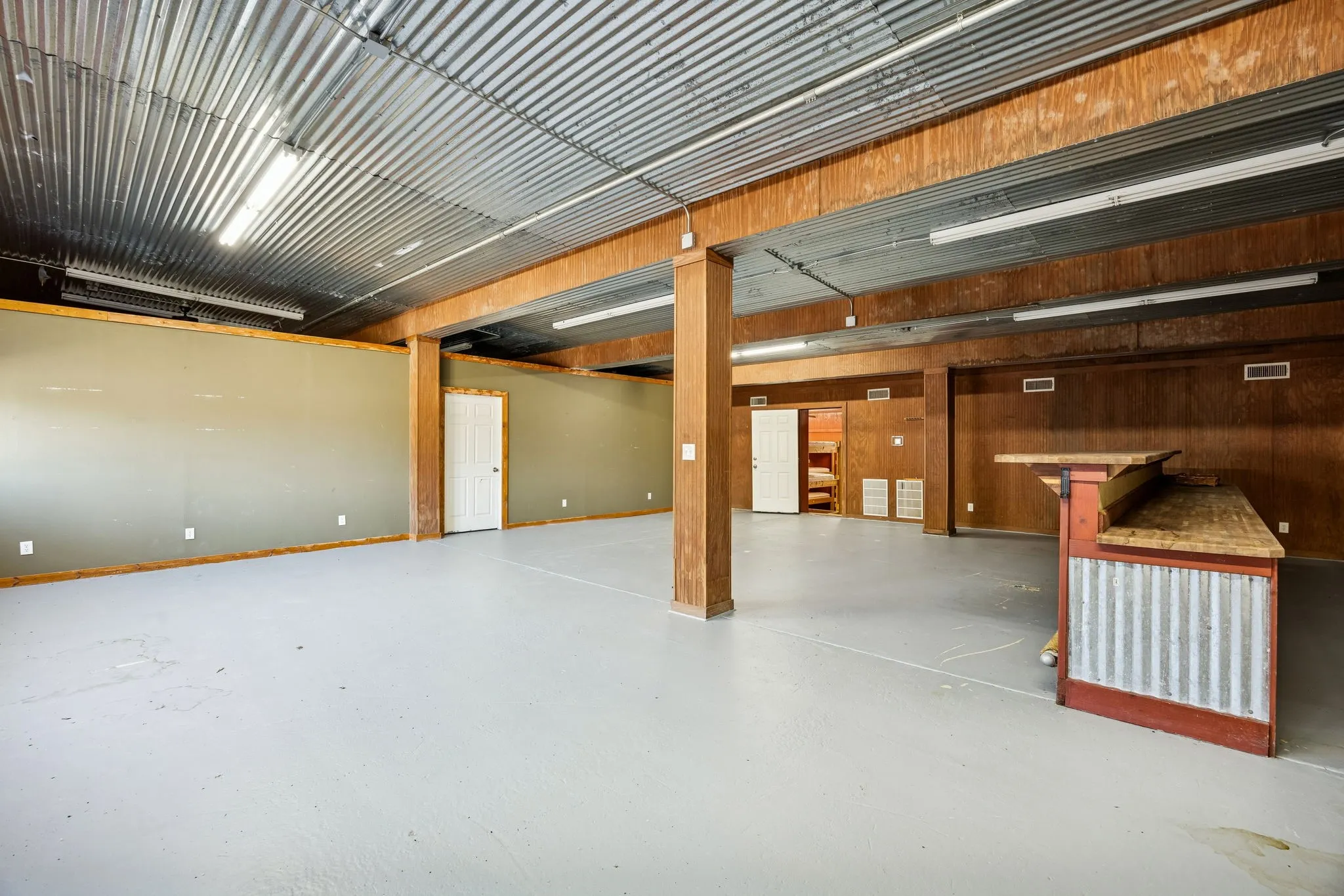 Expansive open space featuring a corrugated metal ceiling and light gray flooring