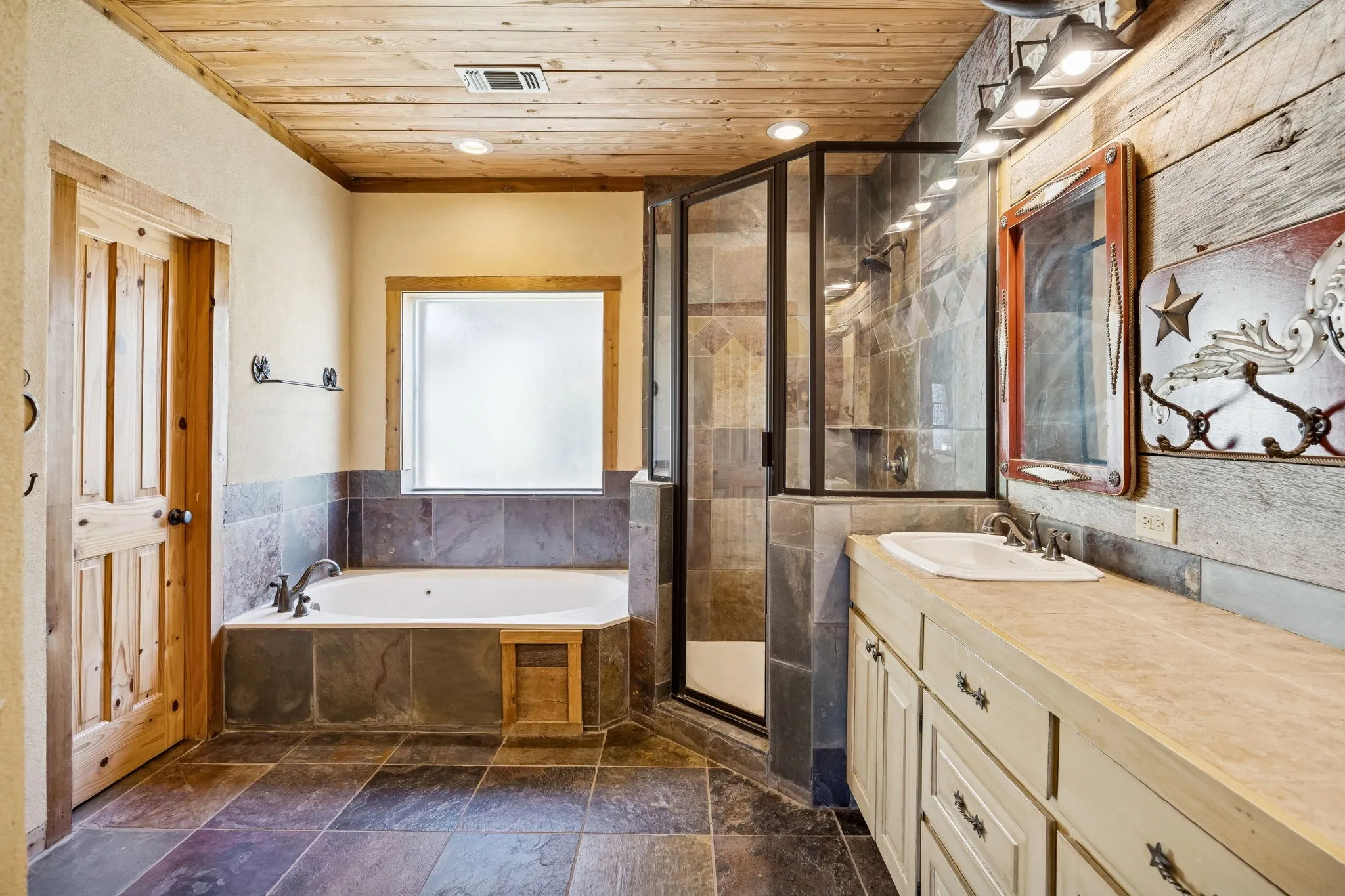 Bathroom featuring a wood-panel ceiling, stone tile flooring, and a glass-enclosed shower