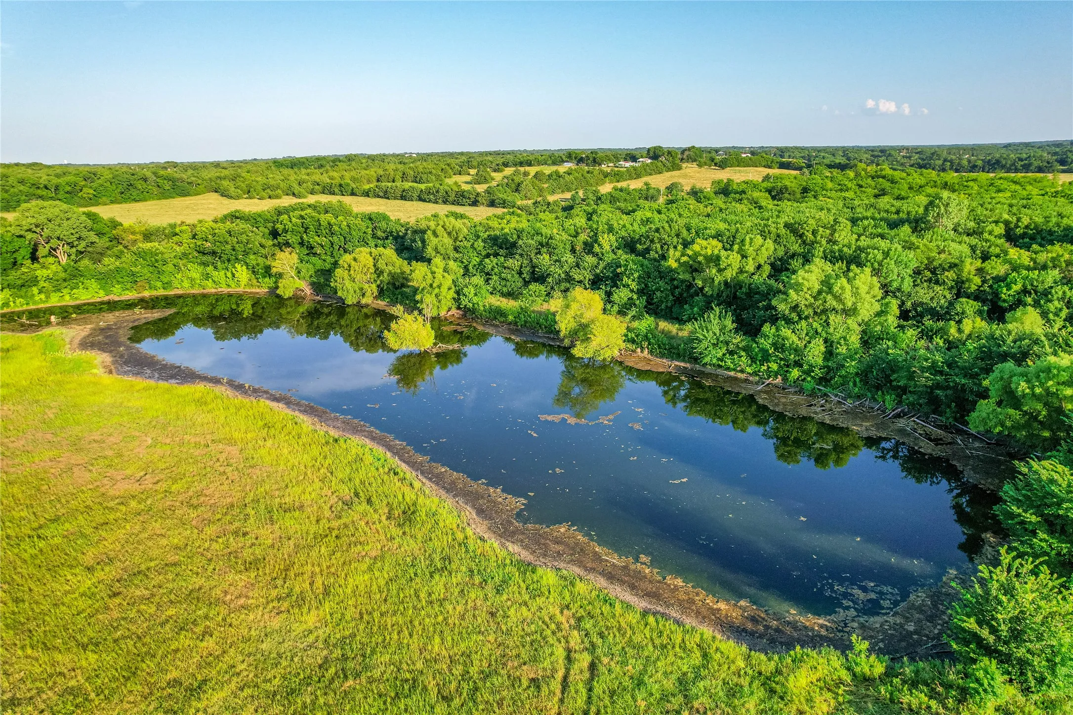 Expansive body of water surrounded by lush greenery and a natural landscape