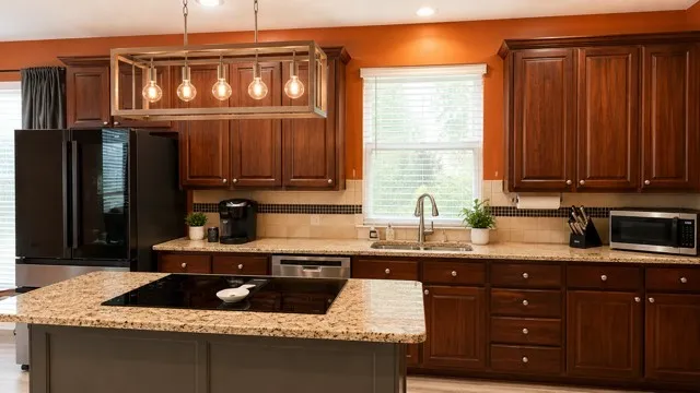 Kitchen featuring a large central island with a built-in cooktop, granite countertops, and rich wood-finish cabinetry