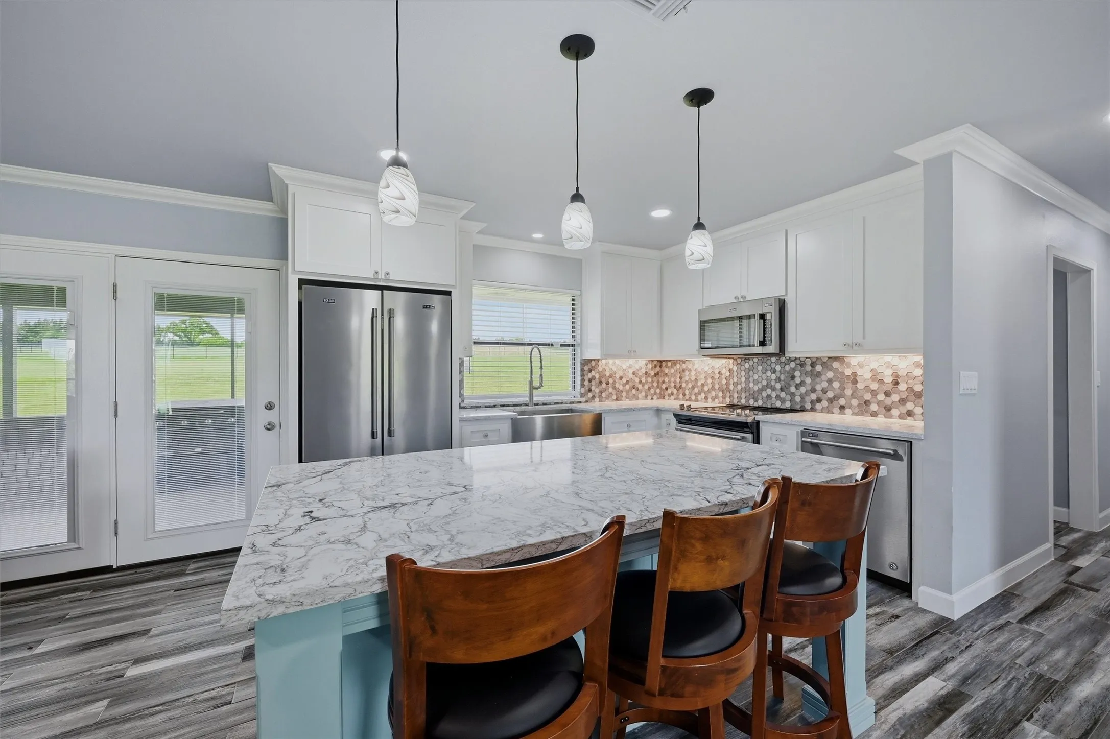 Kitchen area boasts granite countertops, all stainless steel appliances, and direct access to the enclosed back porch.