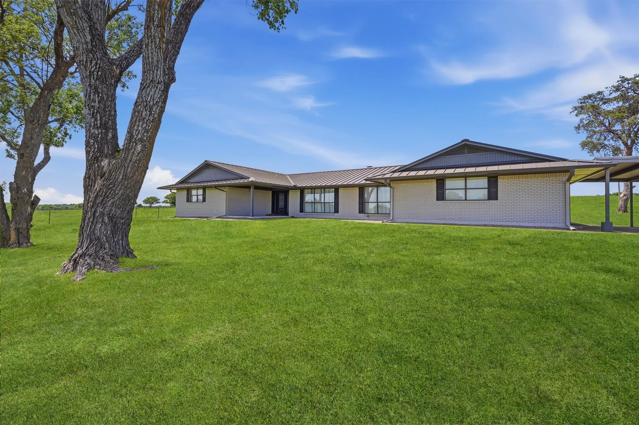 A covered front door and large windows grace the front of the home.