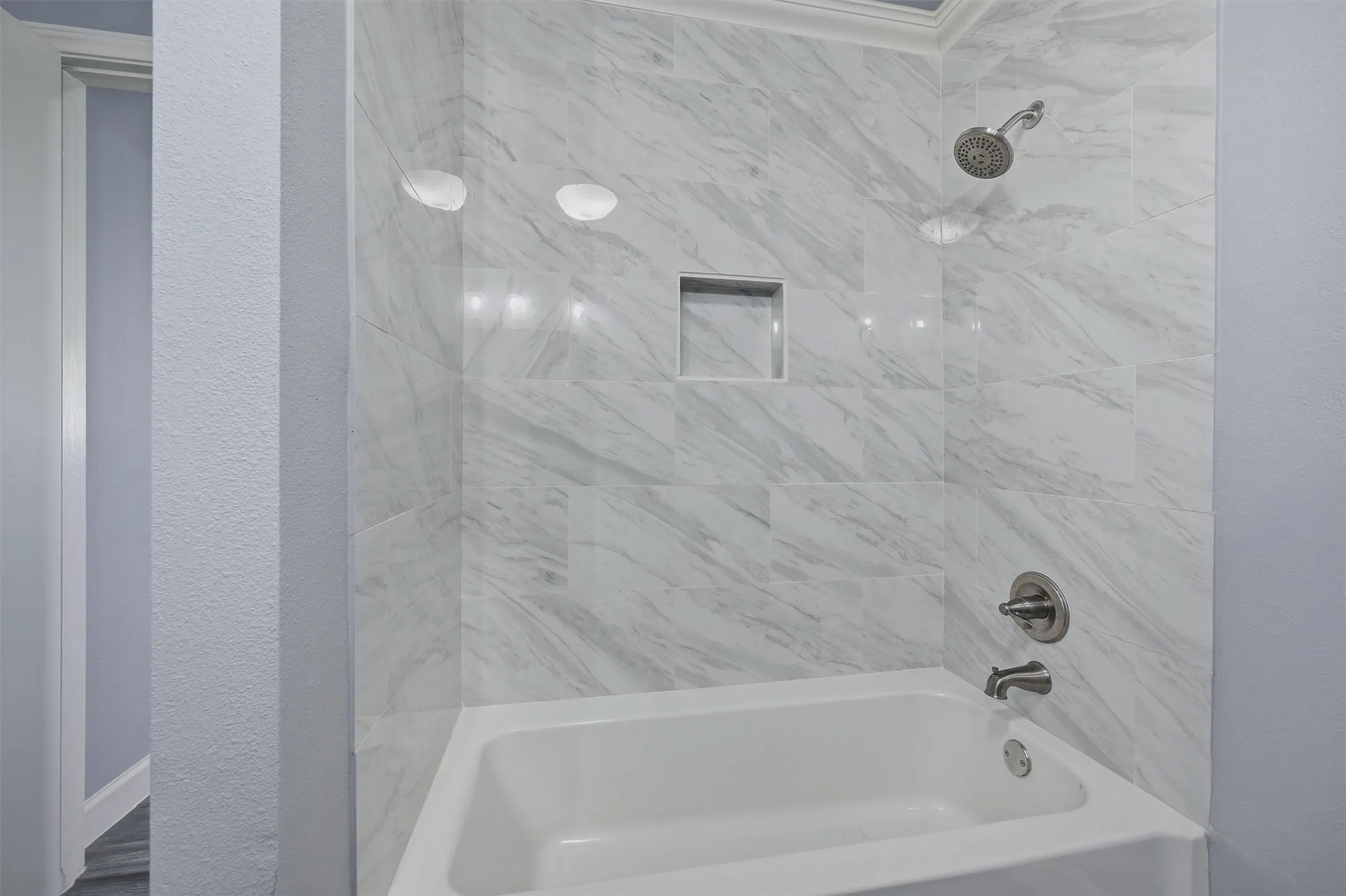 Large tub/shower combination with tile surround in this bathroom.