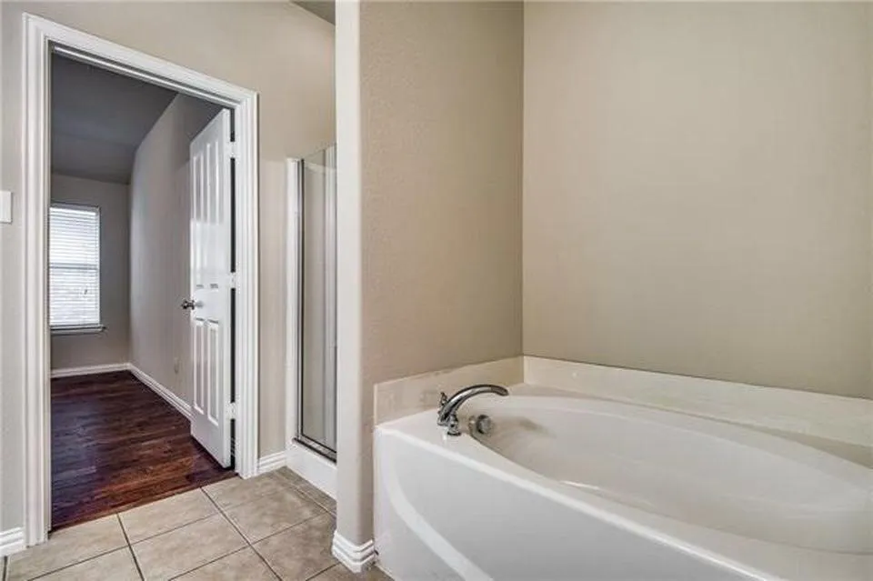 Soaking tub with chrome fixtures and surrounding tile
