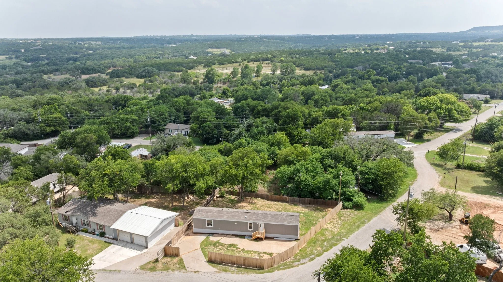 Aerial perspective showcasing two distinct properties within a verdant, expansive landscape