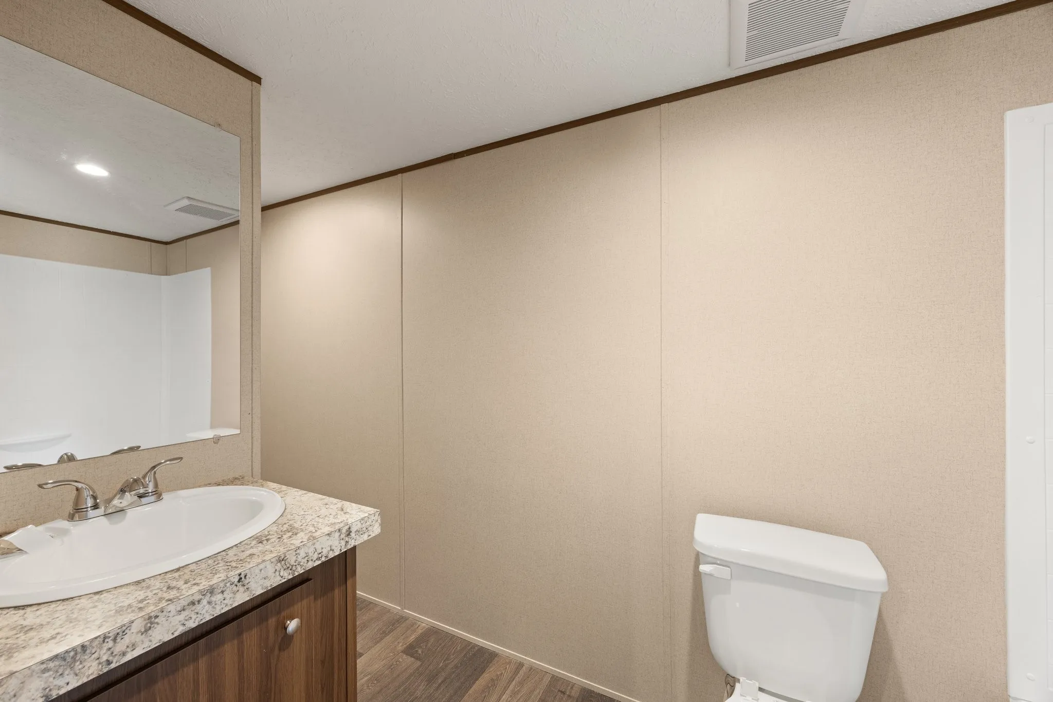 Bathroom featuring a vanity with a laminate countertop, undermount sink, and chrome fixtures