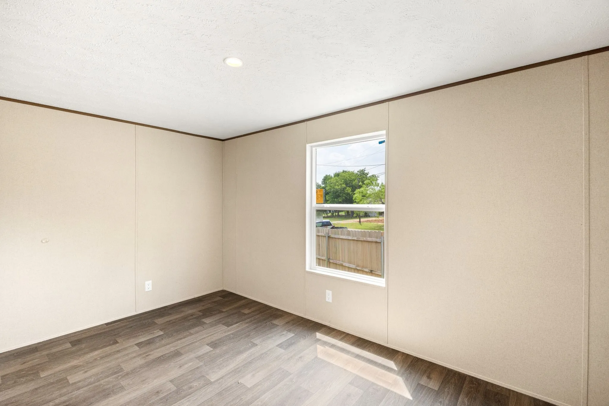Interior room featuring wood-finish flooring, a single pane window, and recessed lighting