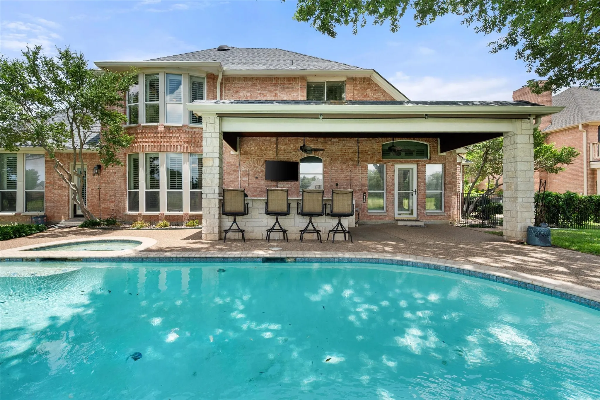 Pool view and covered patio, outdoor kitchen and bar area