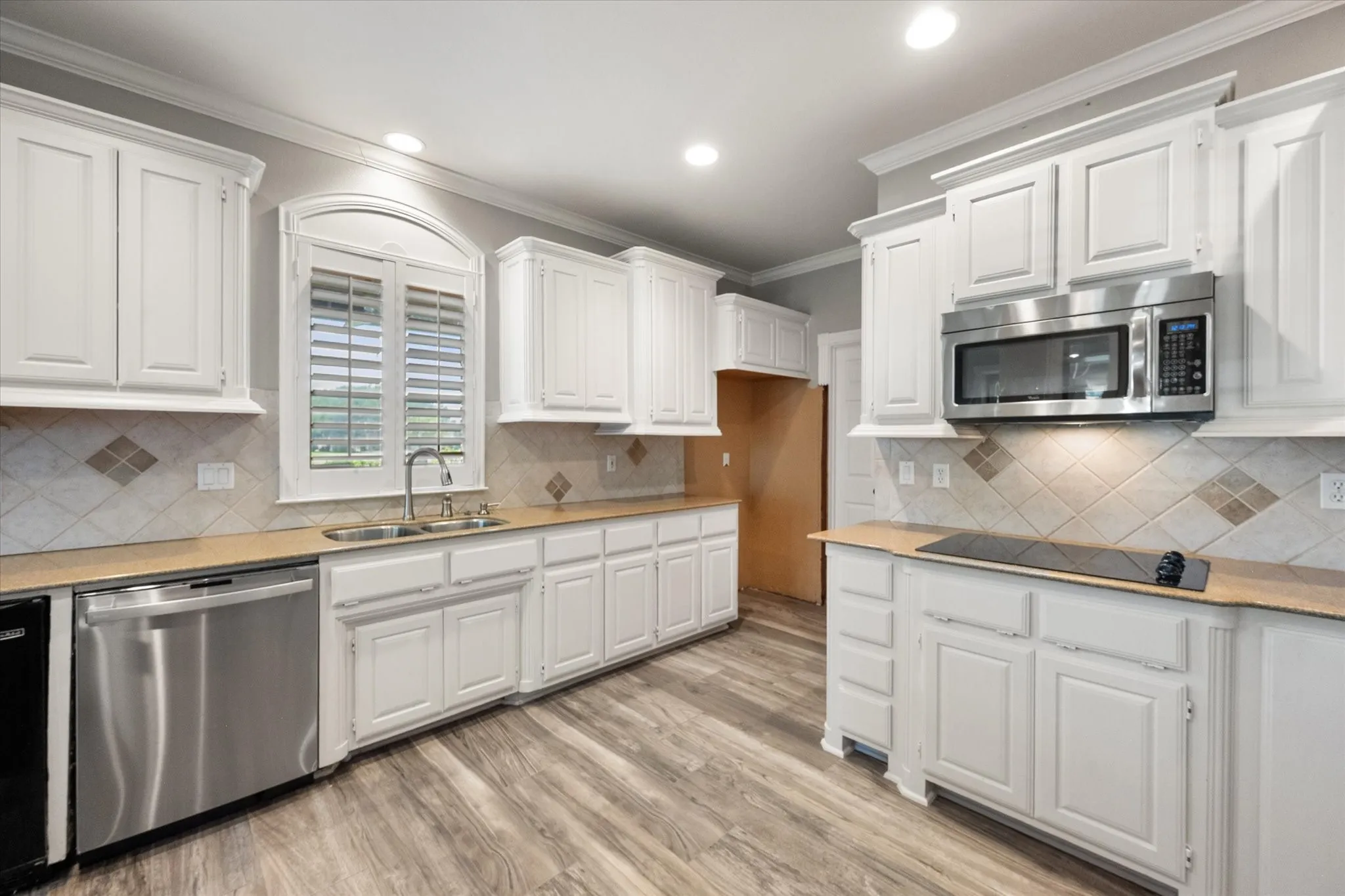 Bright kitchen with windows overlooking the back -electric cooktop and built in microwave.