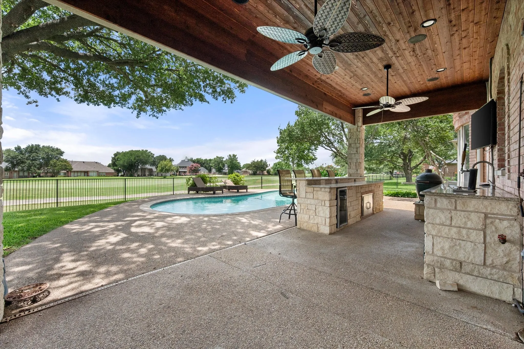 View from covered patio overlooking the pool and the golf course