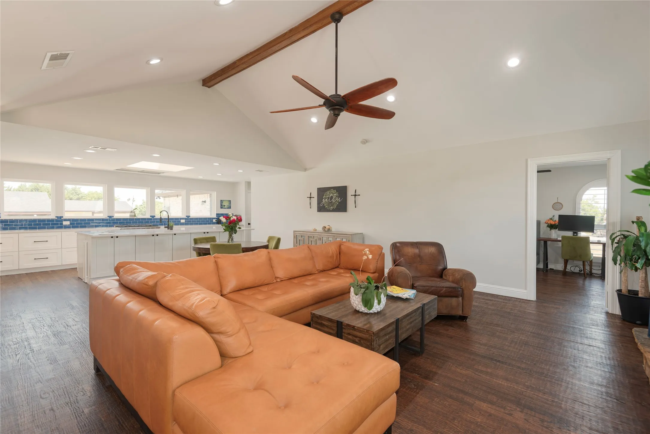 Expansive open-concept great area featuring high vaulted ceilings with a wood beam and recessed lighting