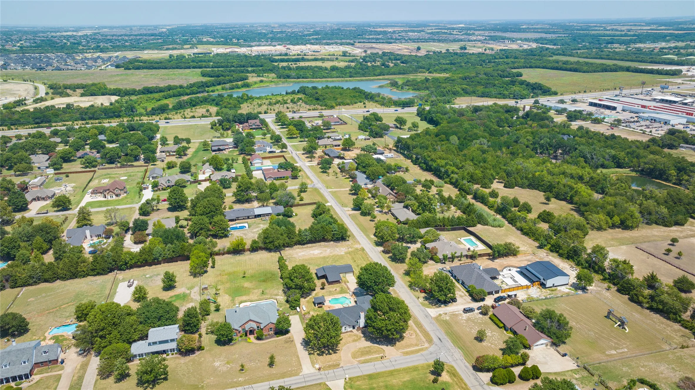 Expansive aerial perspective North showcasing a residential area with various properties featuring private swimming pools
