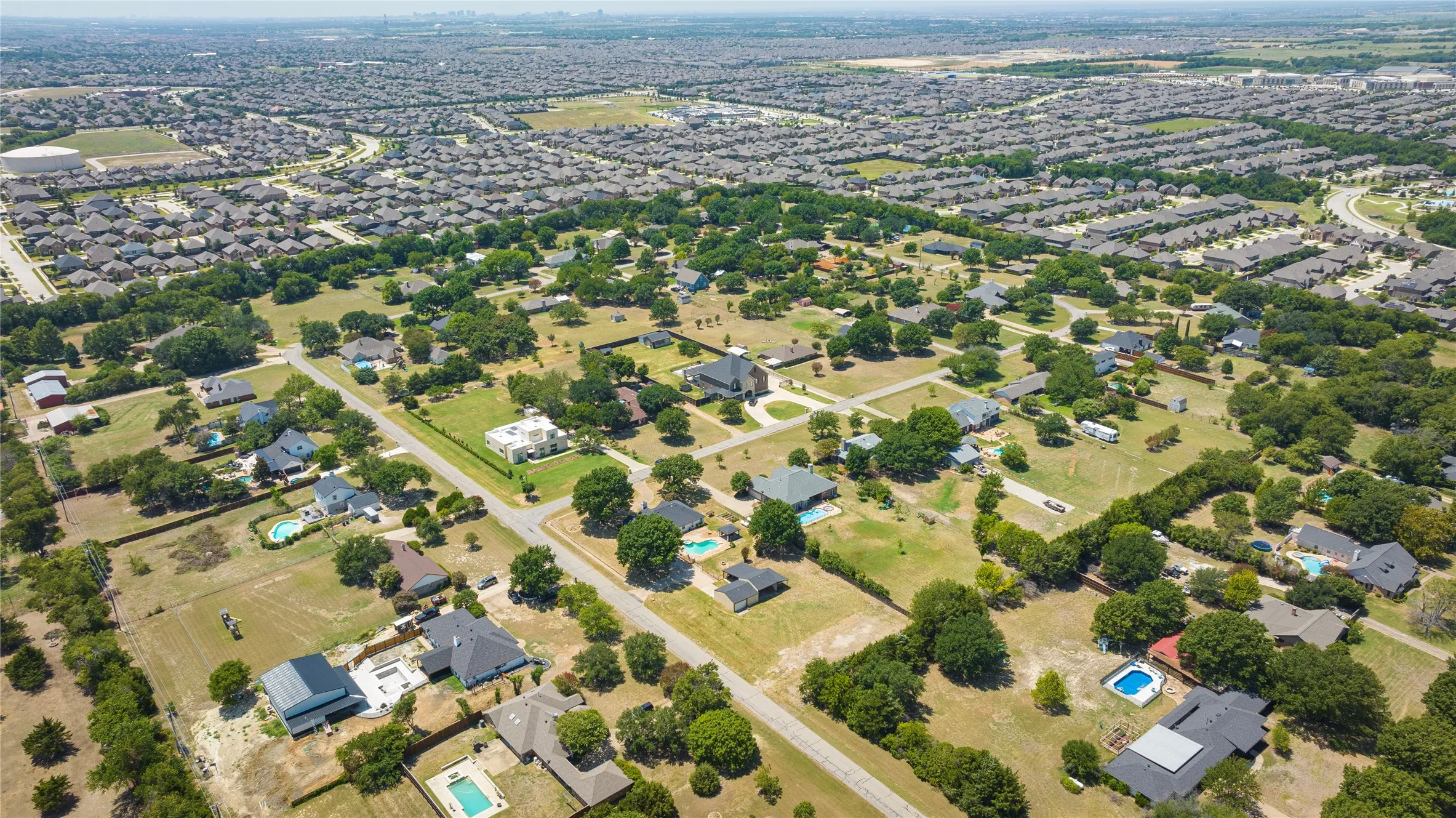 SW view Expansive suburban setting featuring a mix of mature trees and open green spaces