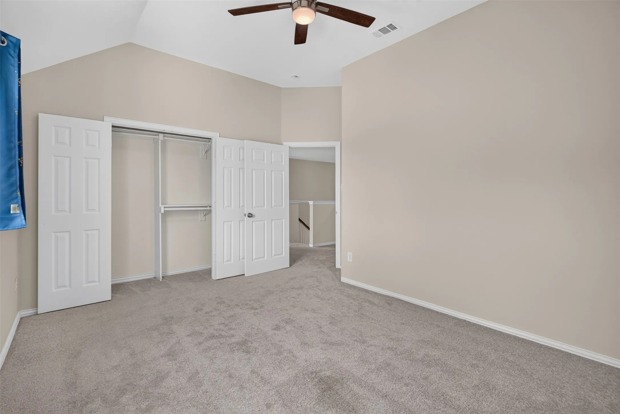 Bedroom featuring vaulted ceilings, neutral wall paint, and soft gray carpeting