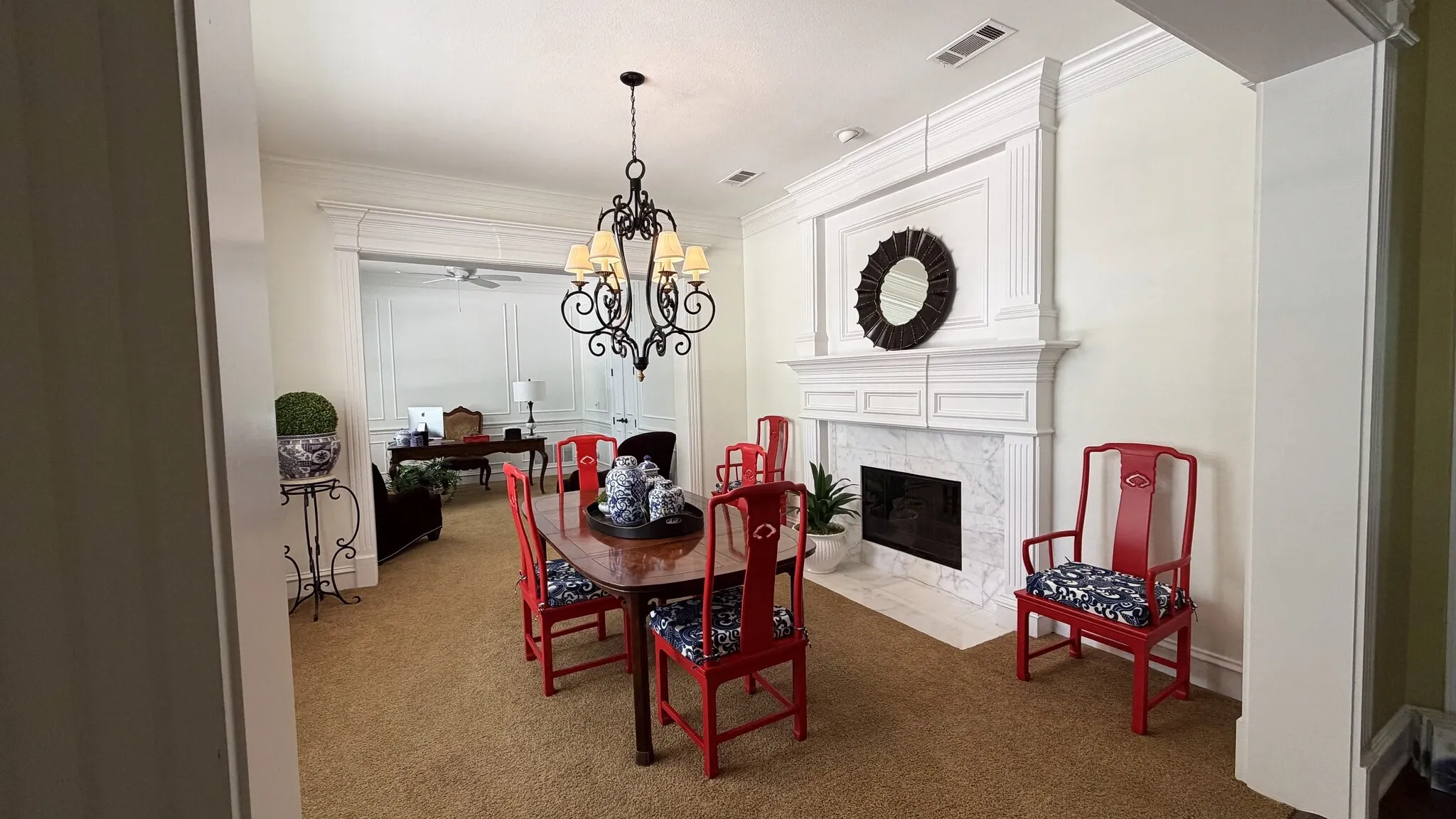 Dining and living areas with a feature fireplace and flows in to another sitting room or office area
