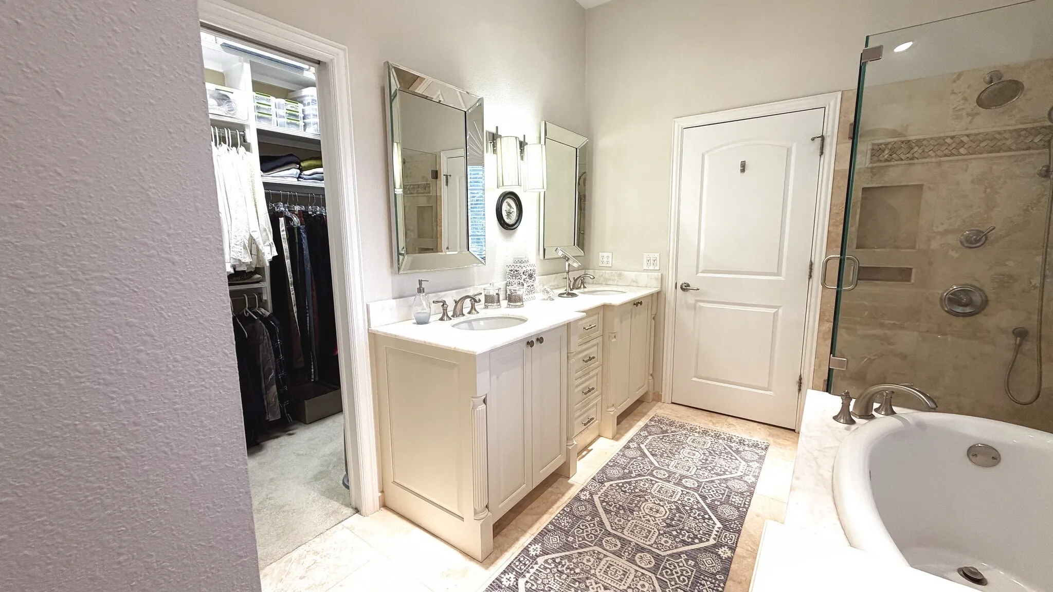 Primary bathroom with double sink vanity, has gorgeous built in cabinets, standing shower and beautiful garden tub