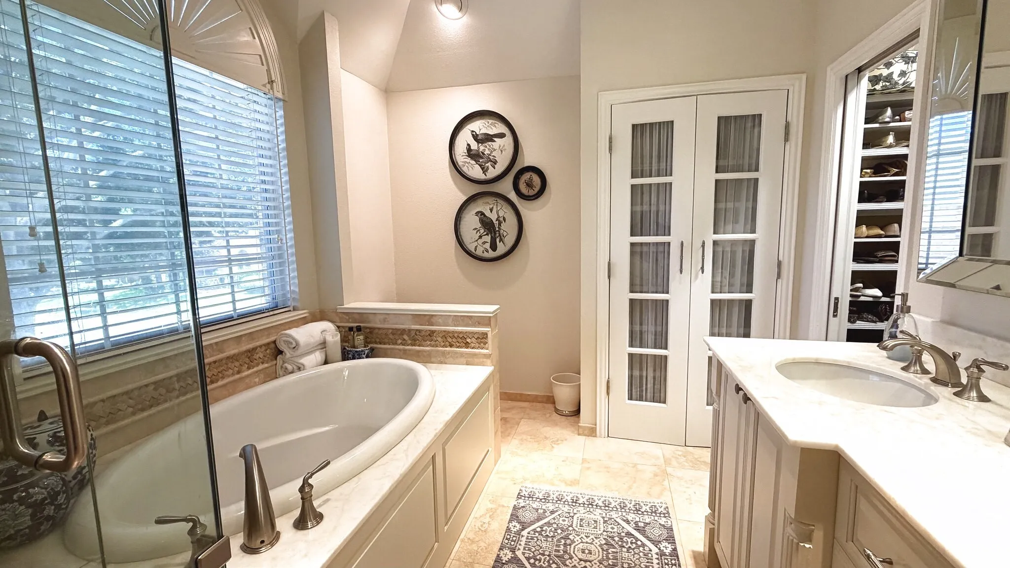 primary bathroom with double sink vanity, has gorgeous built in cabinets, standing shower and beautiful garden tub