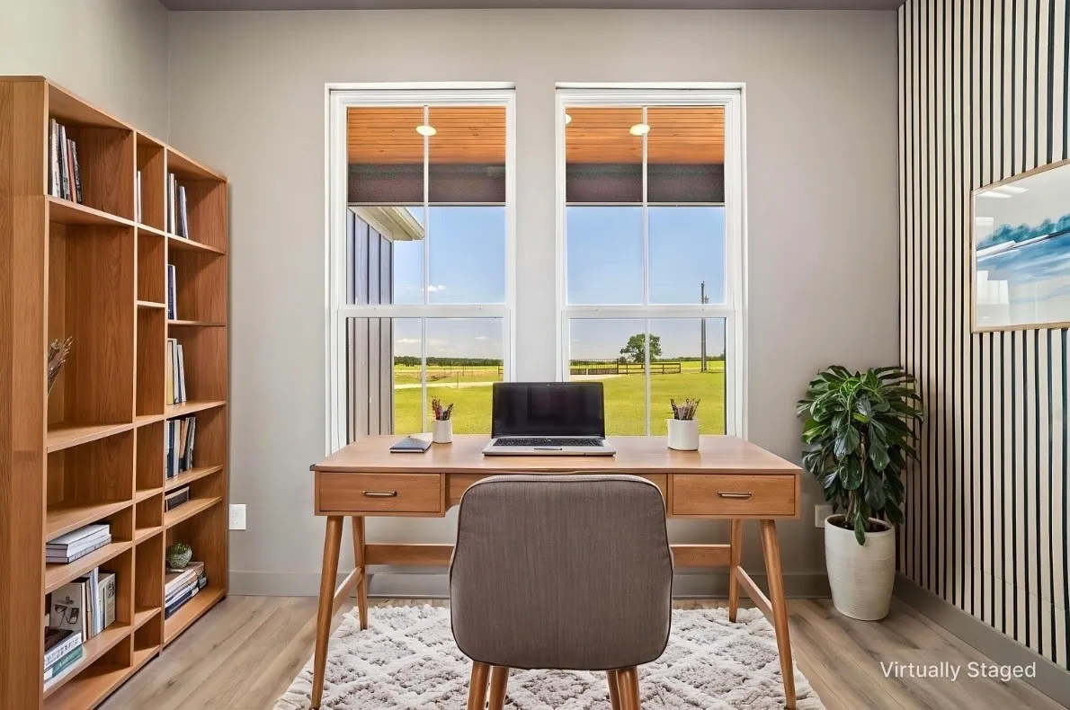 Dual windows, wood-finish flooring, built-in shelving, accent wall paneling, and an open desk area - VIRTUALLY STAGED — FURNISHINGS NOT INCLUDED