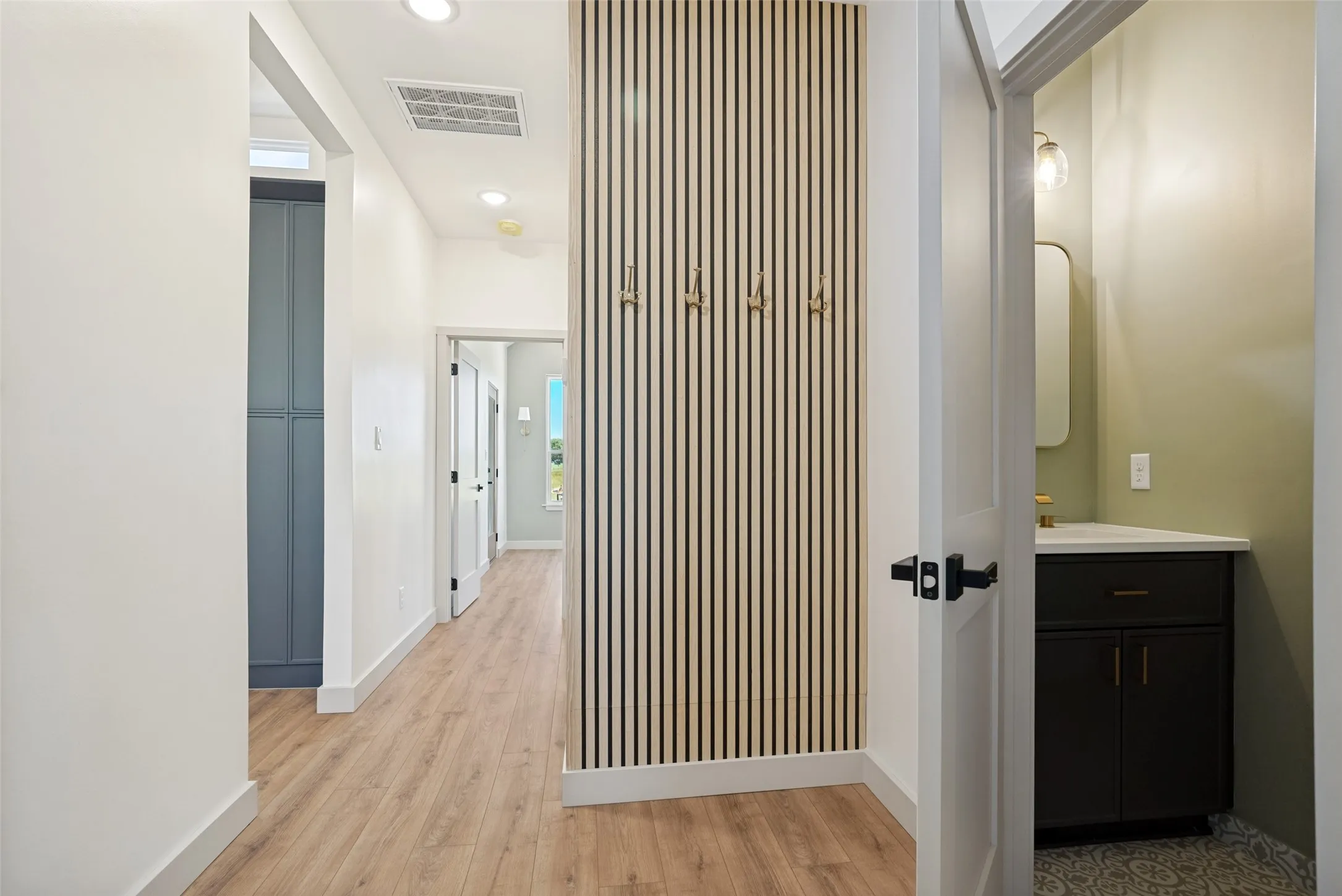 A stylish garage-entry drop zone creates the perfect landing spot for coats, shoes, backpacks, and all of life's daily essentials alongside it you will find the powder room.