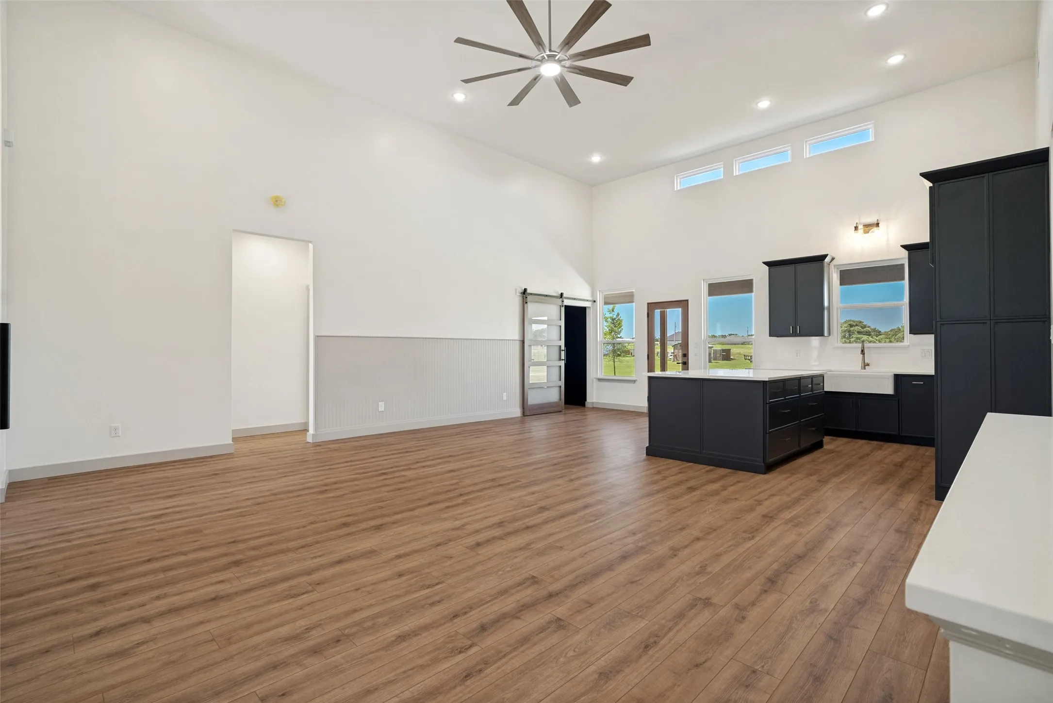 Open-concept living area with vaulted ceilings and wood-finish flooring