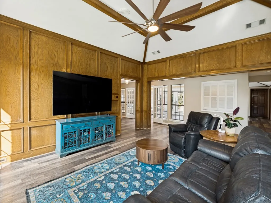 Vaulted ceiling with wood beams and a ceiling fan