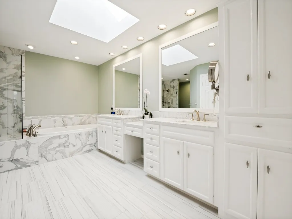 Dual vanity setup featuring white cabinetry, undermount sinks, and light-toned countertops