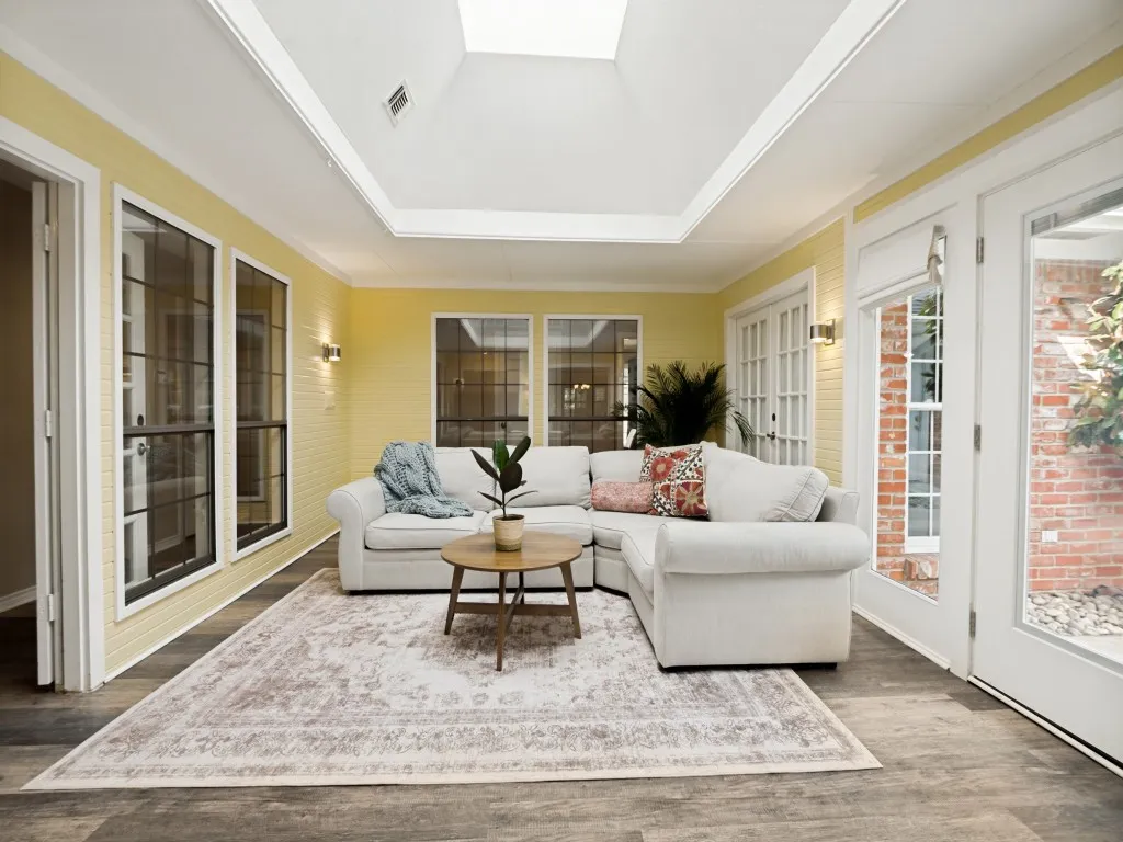Sunroom featuring a skylight, wood-finish flooring, and multiple glass-paned doors