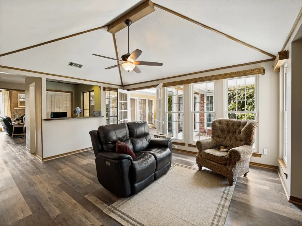 Vaulted ceiling with wood-finish beams and a ceiling fan