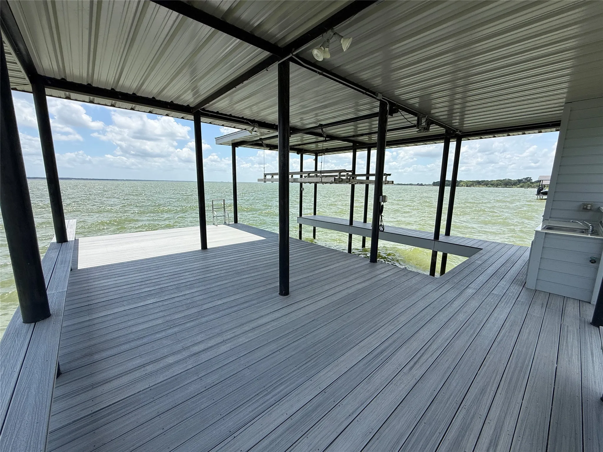 Premium boathouse features Trex decking, double railings, and a covered boat slip with electric lift.