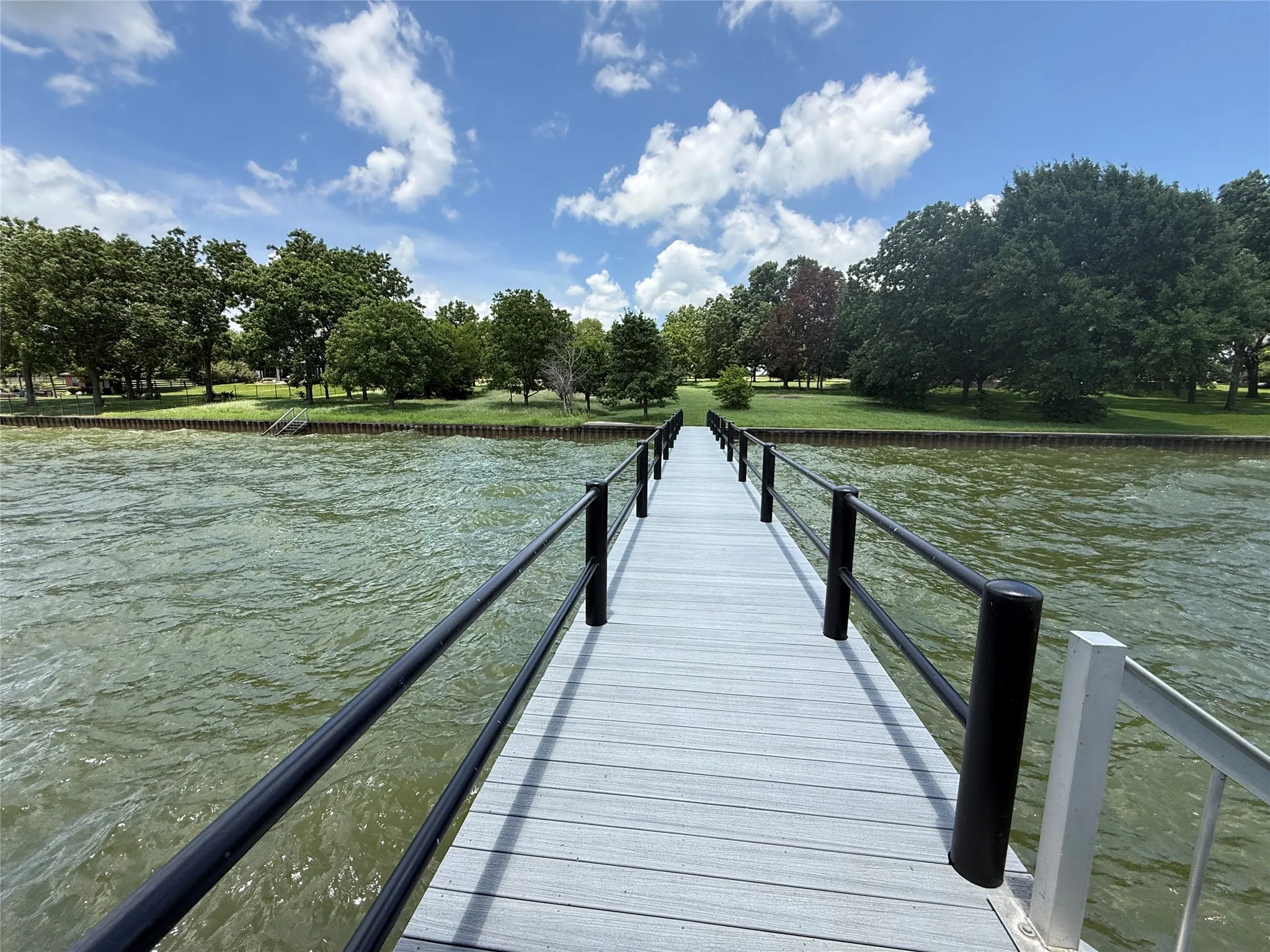 Follow the long walkway to a custom boathouse positioned on wide-open water.