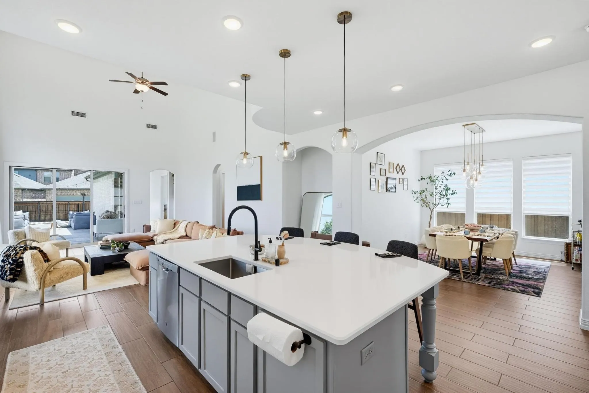 Kitchen island with white countertop, integrated sink, and gray cabinetry