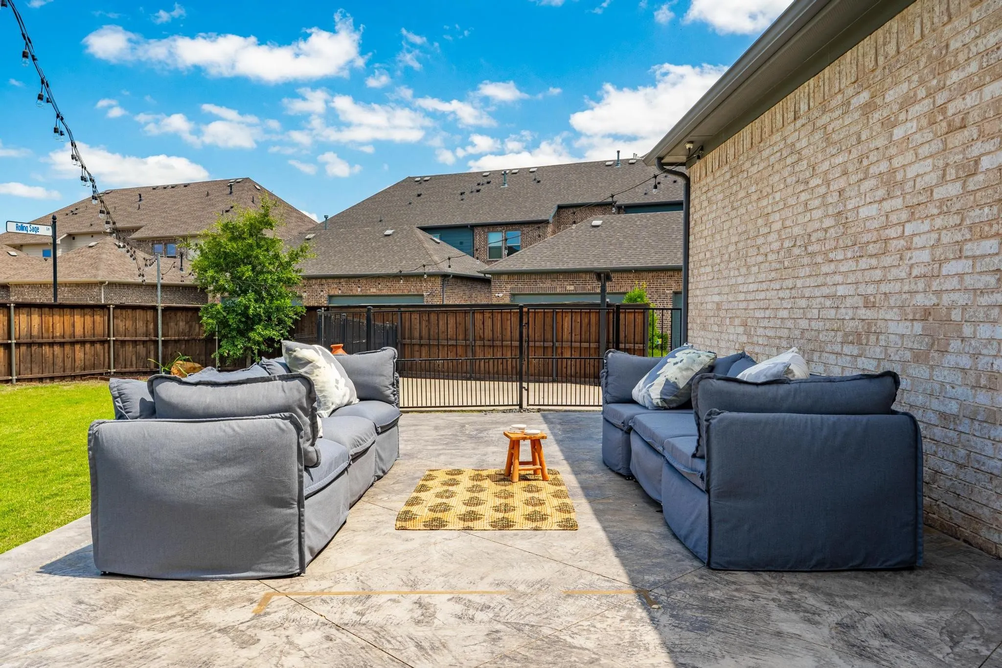 Stamped concrete patio with a light brick exterior and dark gutters