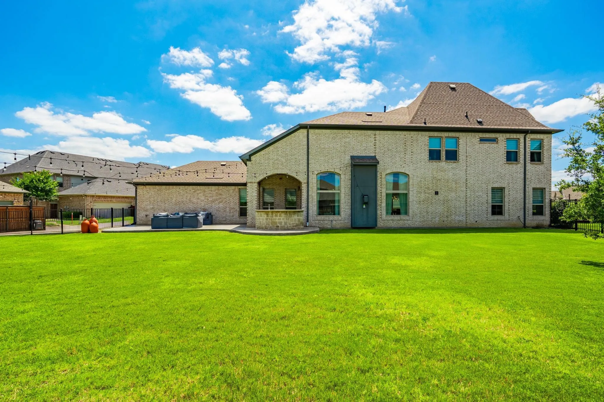 Expansive green lawn with a two-story brick exterior home