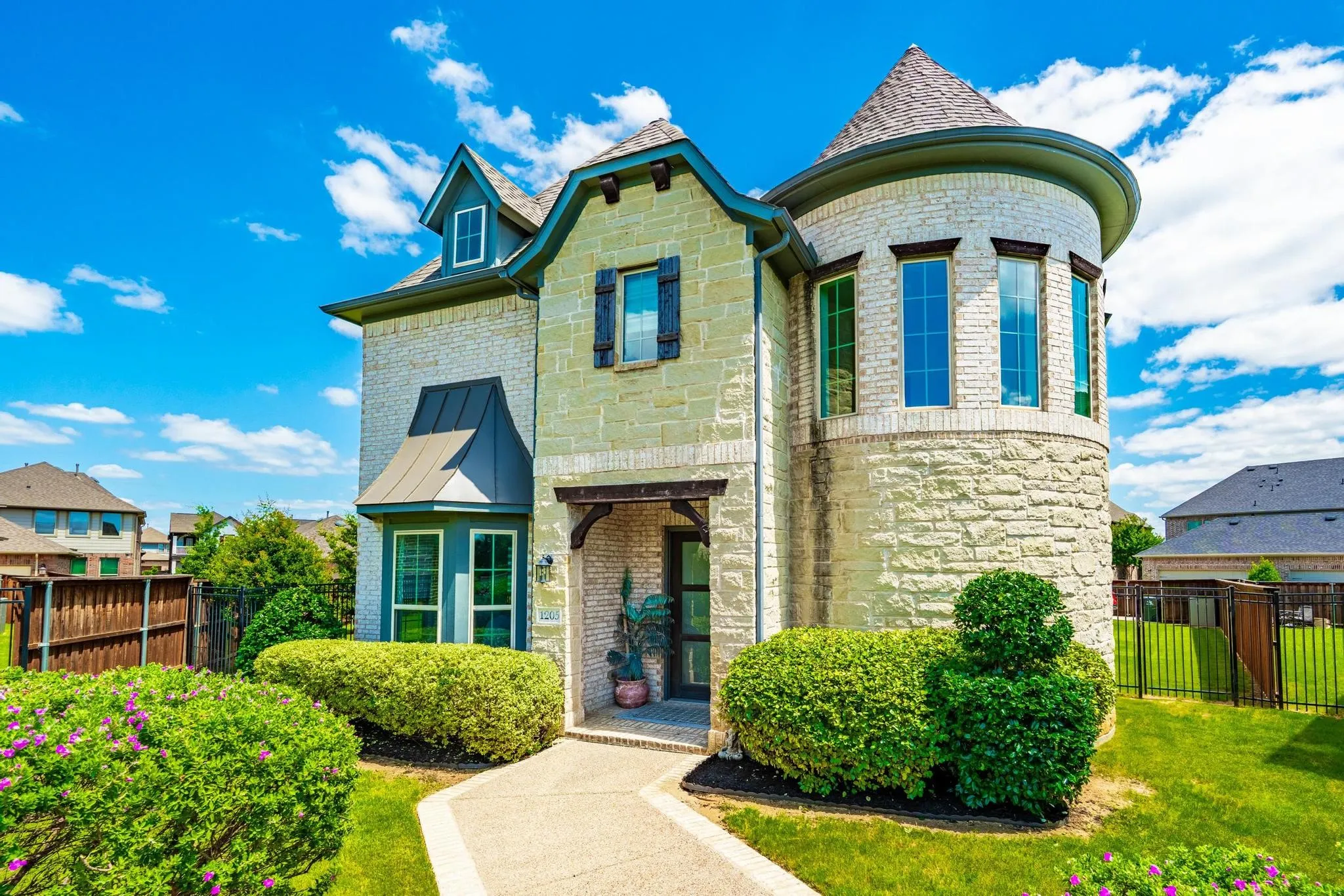 Stone and brick exterior featuring a prominent turretted section with multiple windows