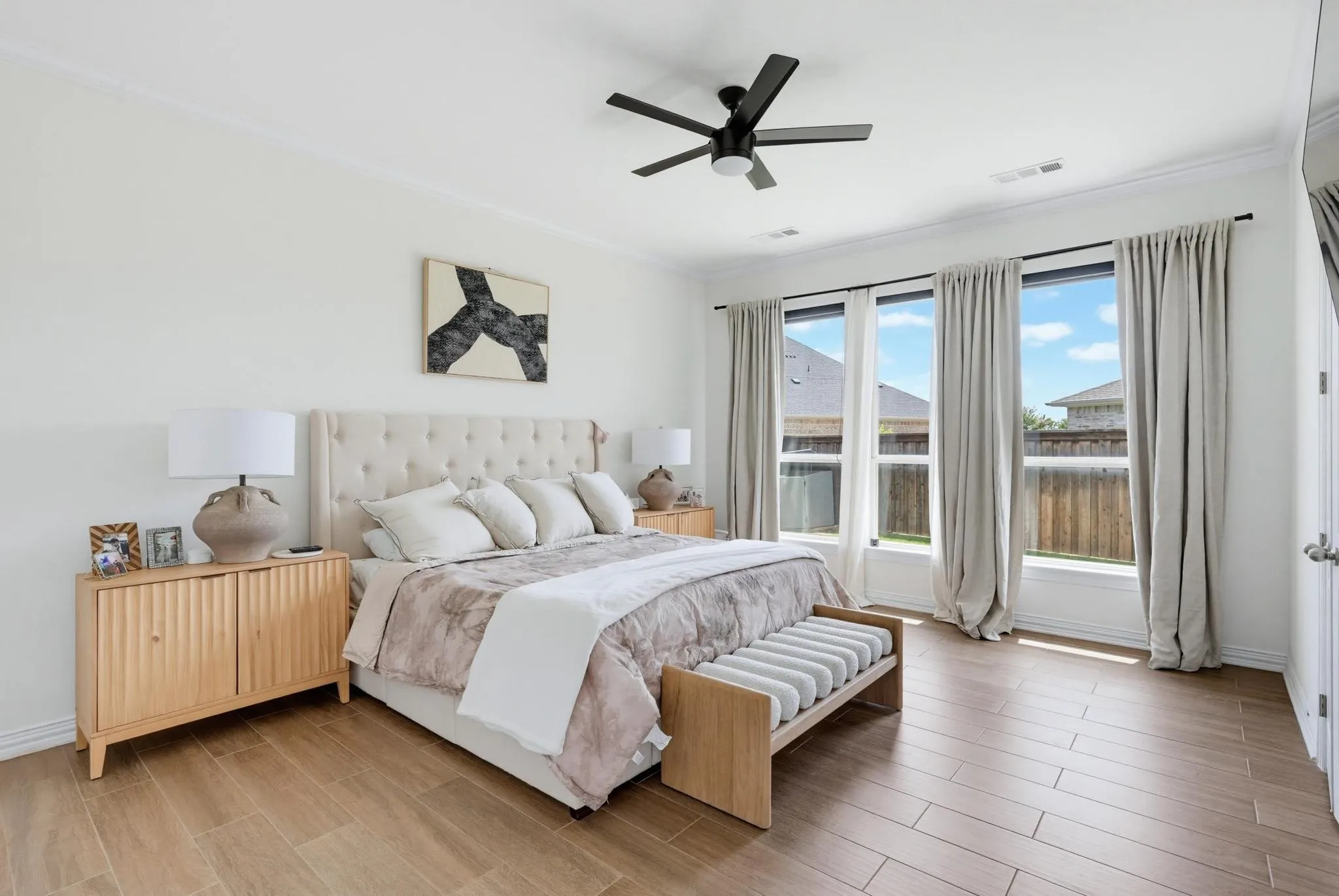 Bright room featuring wood-finish flooring, a contemporary ceiling fan, and crown molding