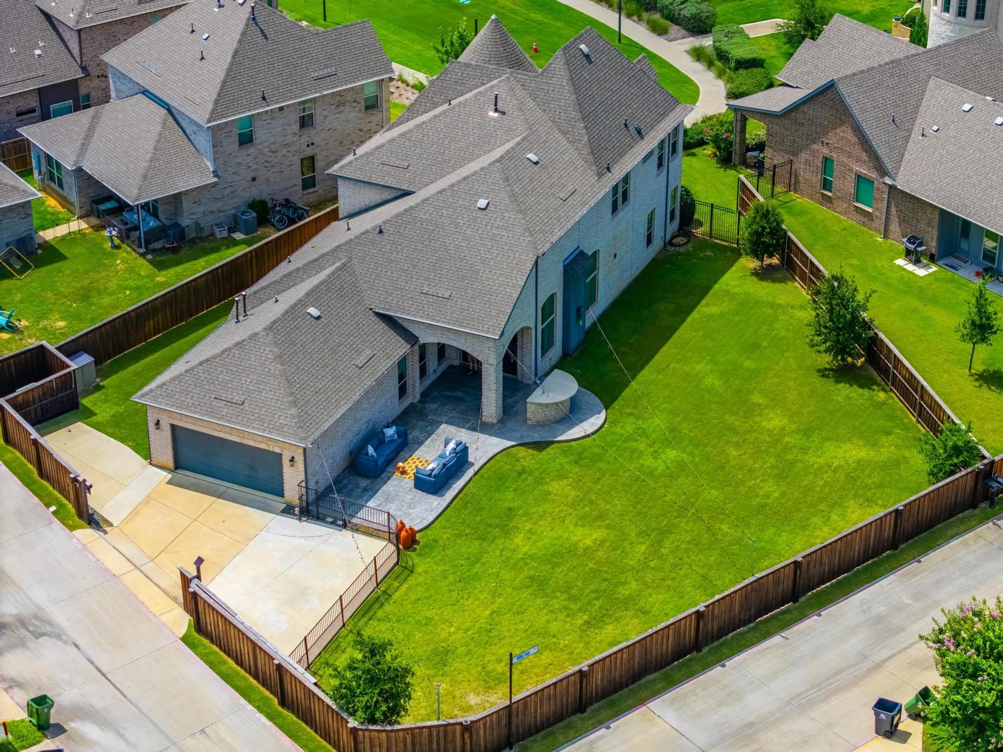 Expansive fenced backyard featuring a manicured lawn and mature trees
