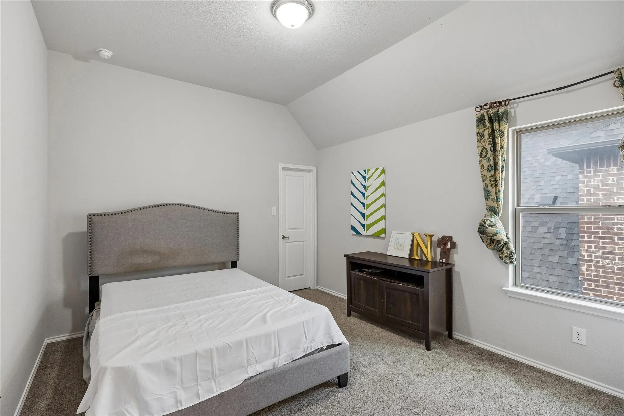 Bedroom featuring neutral wall paint, carpet flooring, a window with white trim, and a white interior door