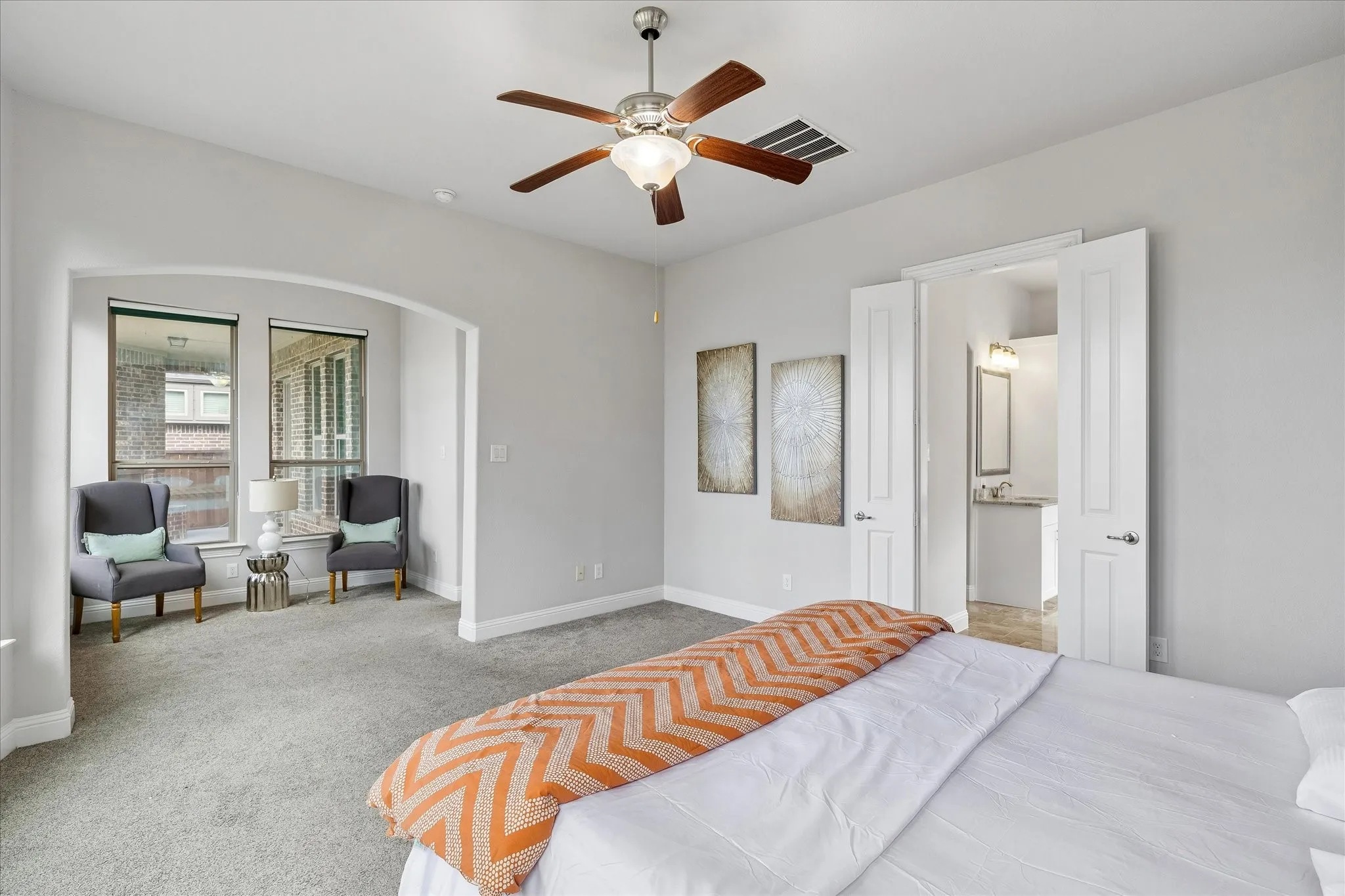 Spacious bedroom featuring light gray carpeting and a ceiling fan with light fixture