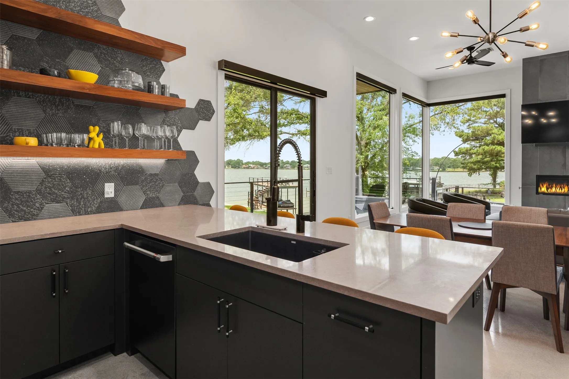 Open-concept kitchen featuring a large island with an undermount sink and a matte black gooseneck faucet