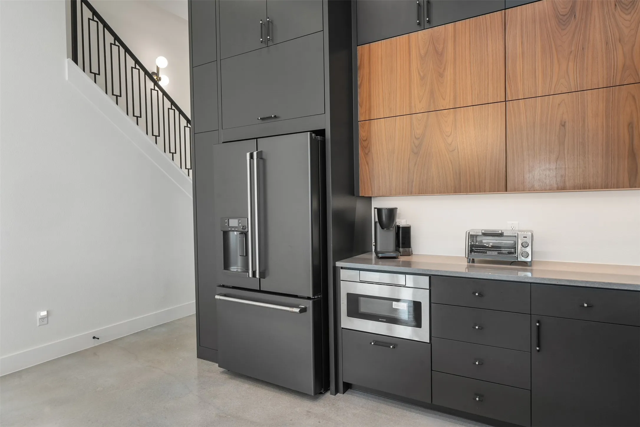 Integrated kitchen cabinetry featuring two-tone finishes, stainless steel appliances, and a built-in microwave