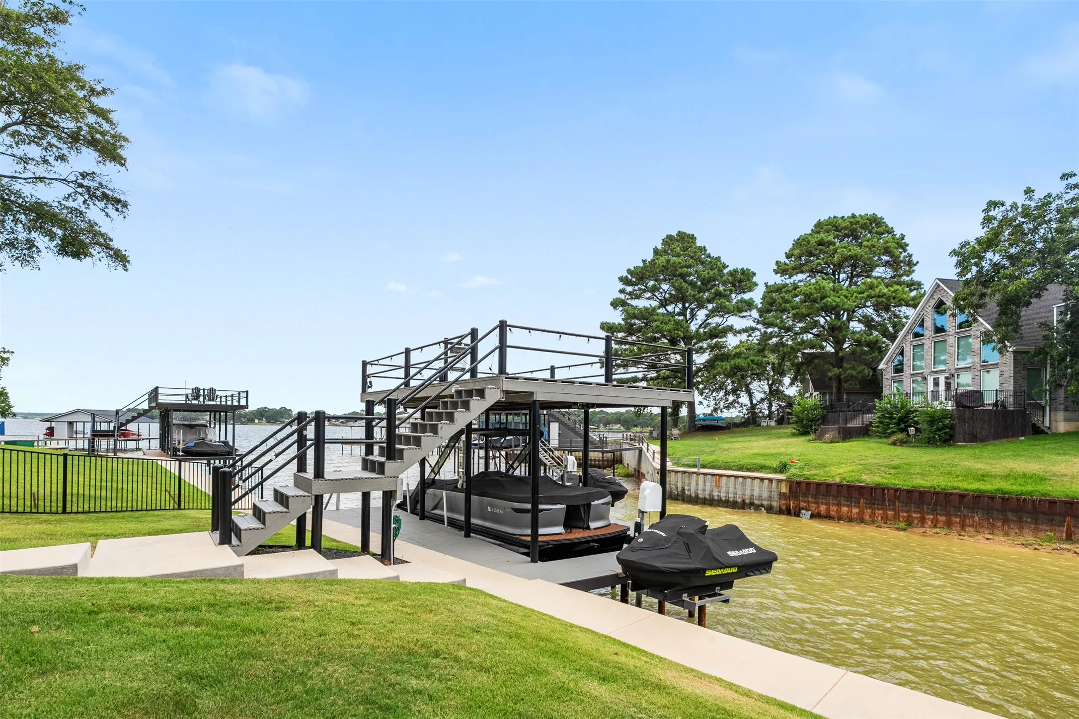 Two-story dock structure featuring a boat lift and an upper-level deck with black railings