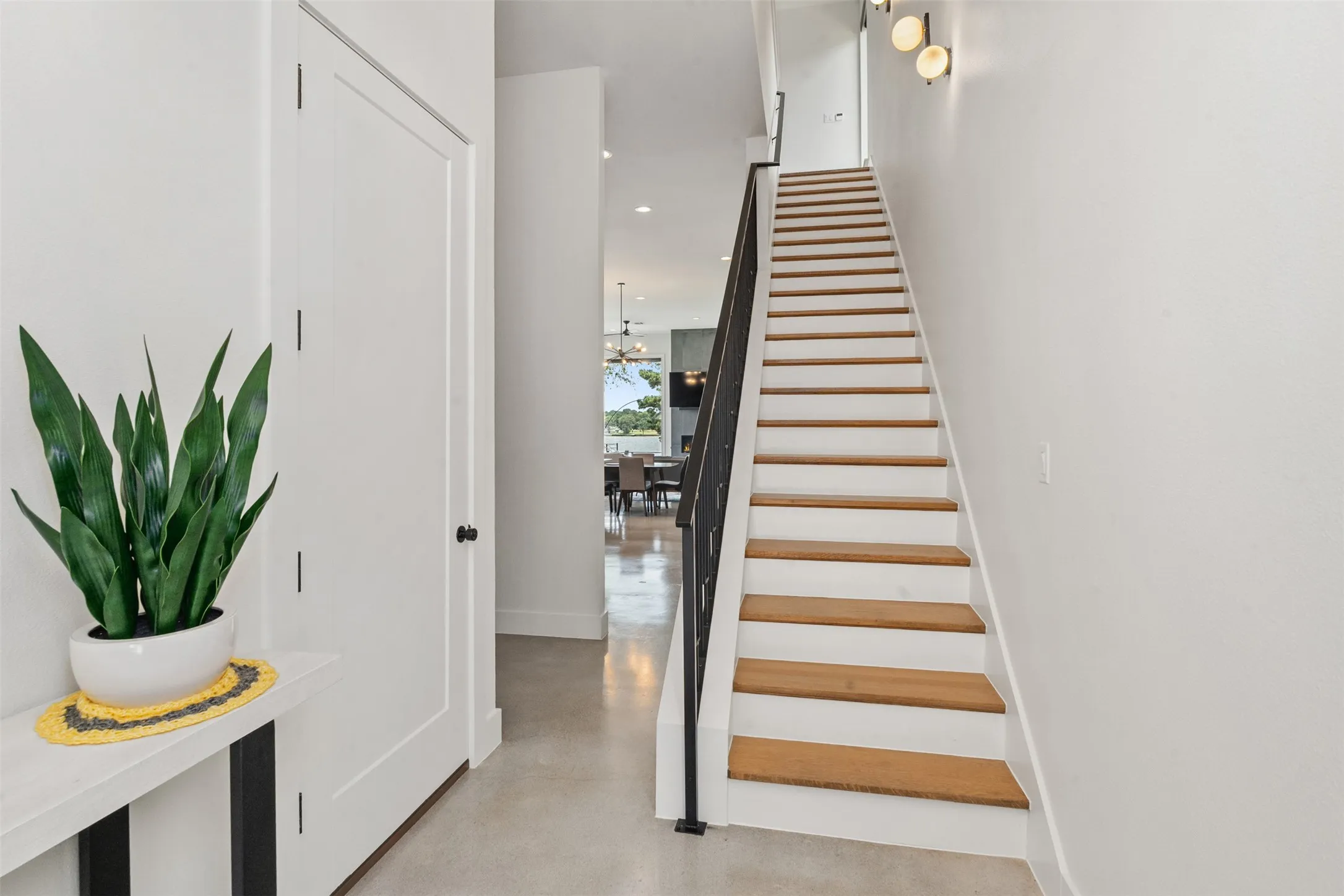 Modern staircase featuring wood-finish treads and a dark metal railing