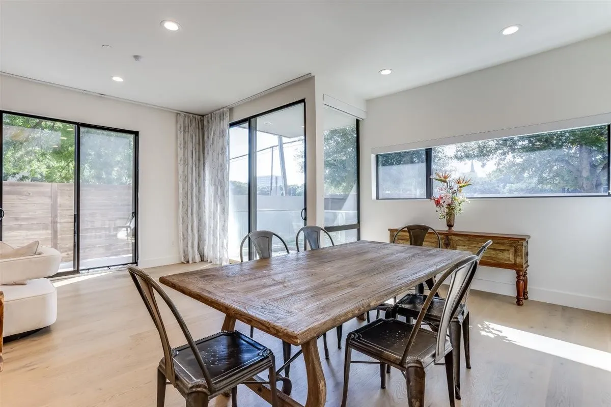 Dining area featuring light wood-finish flooring, recessed lighting, and multiple large windows